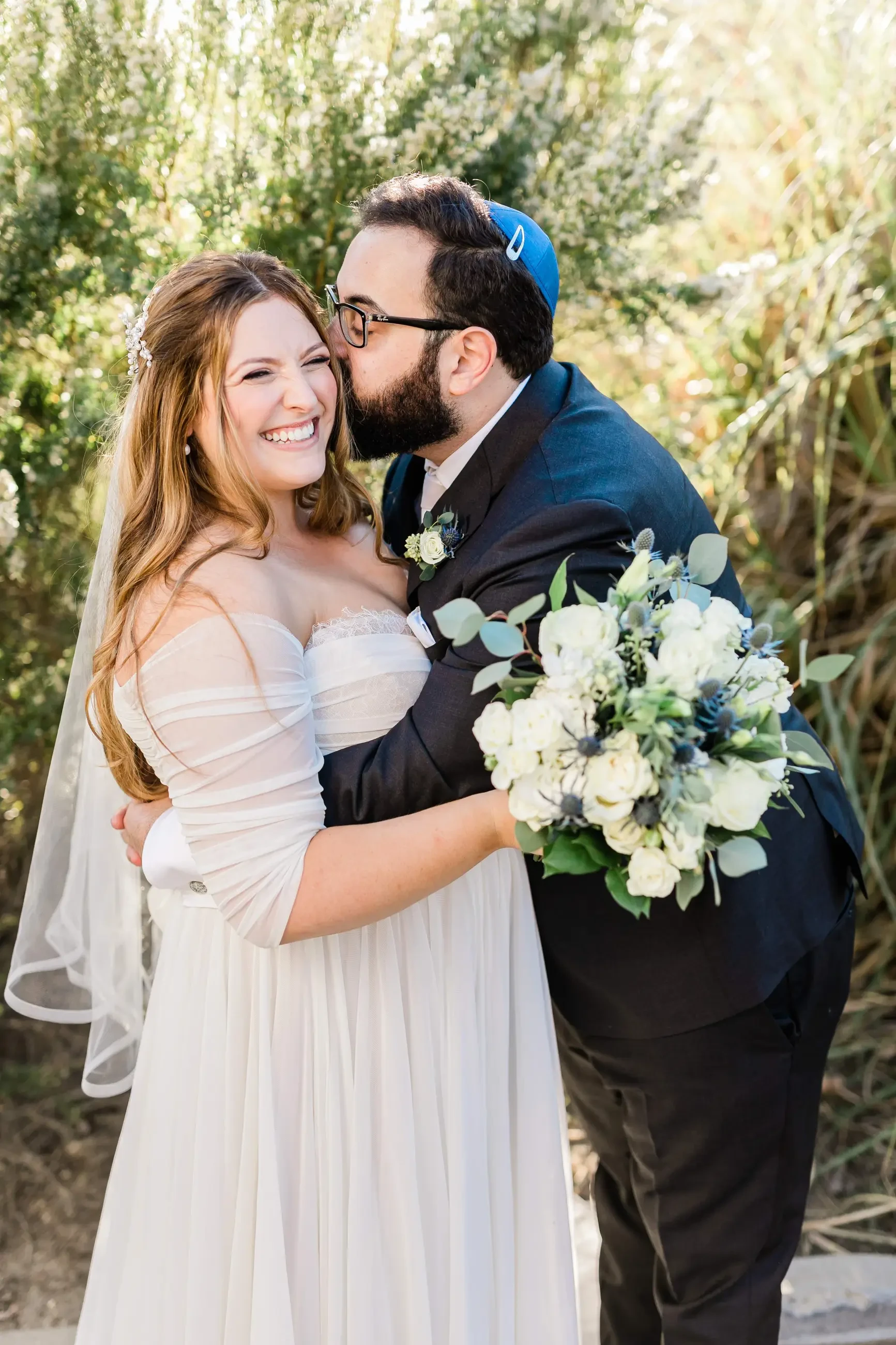 Kissing couple wearing a white gown and a black suit