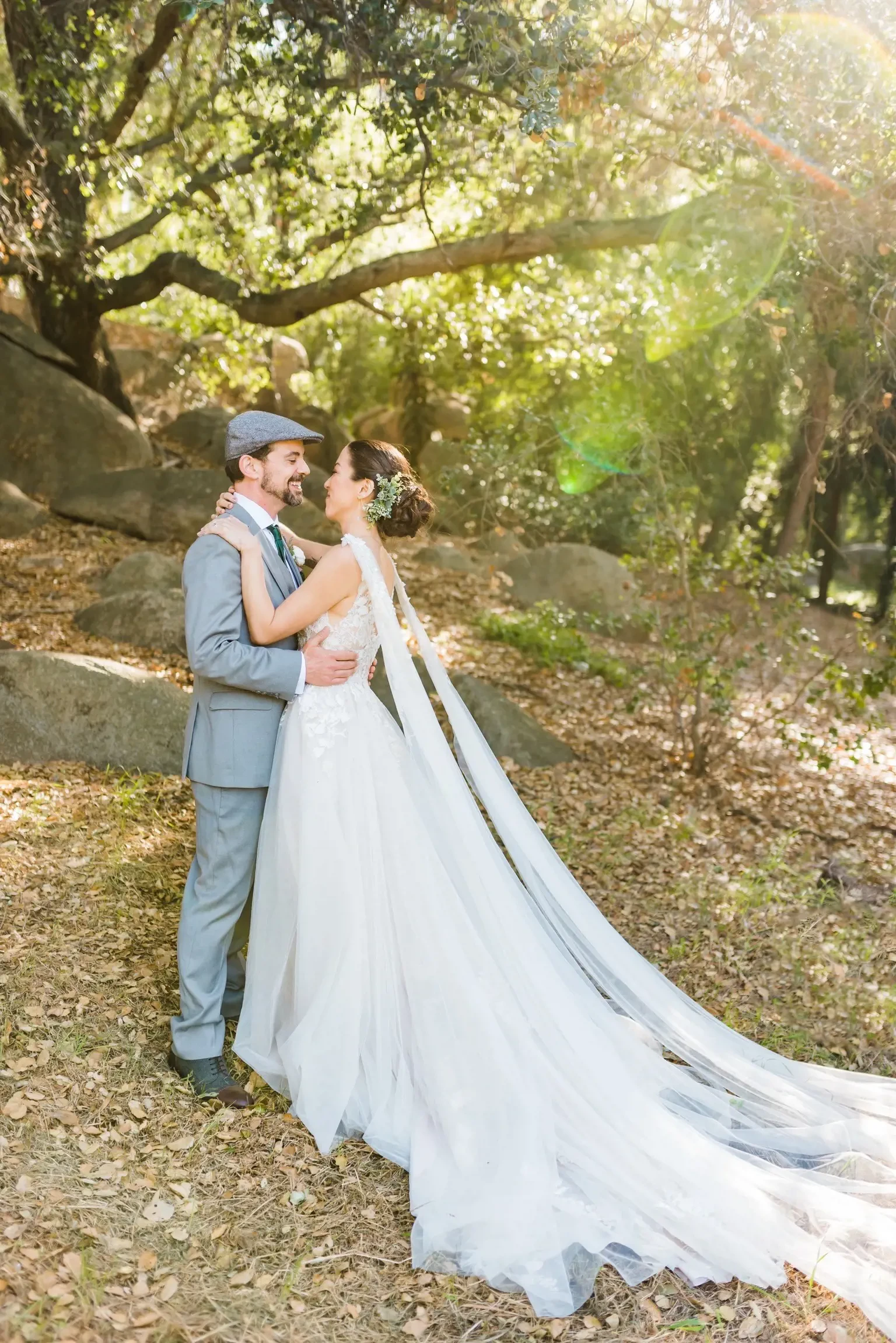 Сouple wearing a white gown and a gray suit in the woods
