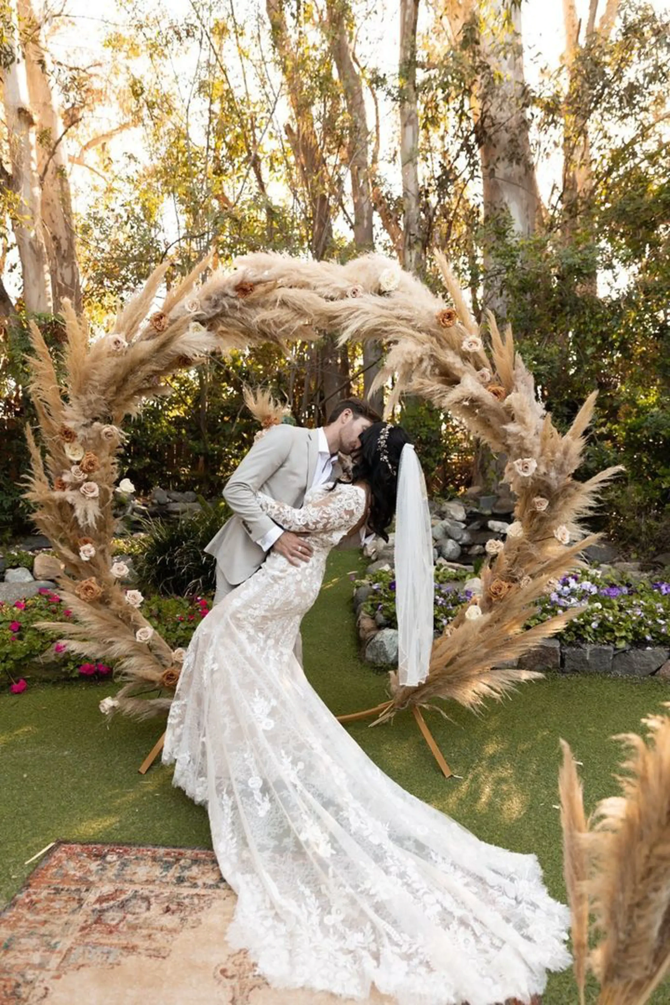 Сouple wearing a white gown and a gray suit on the grass