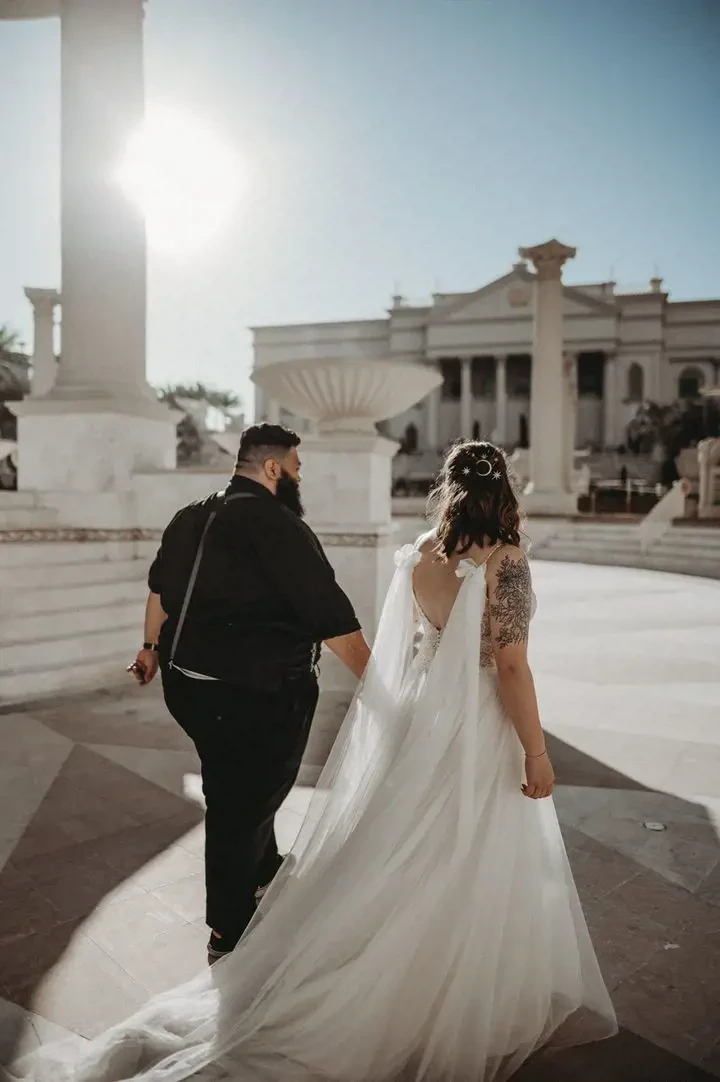 Сouple wearing a white gown and a black suit in the  area