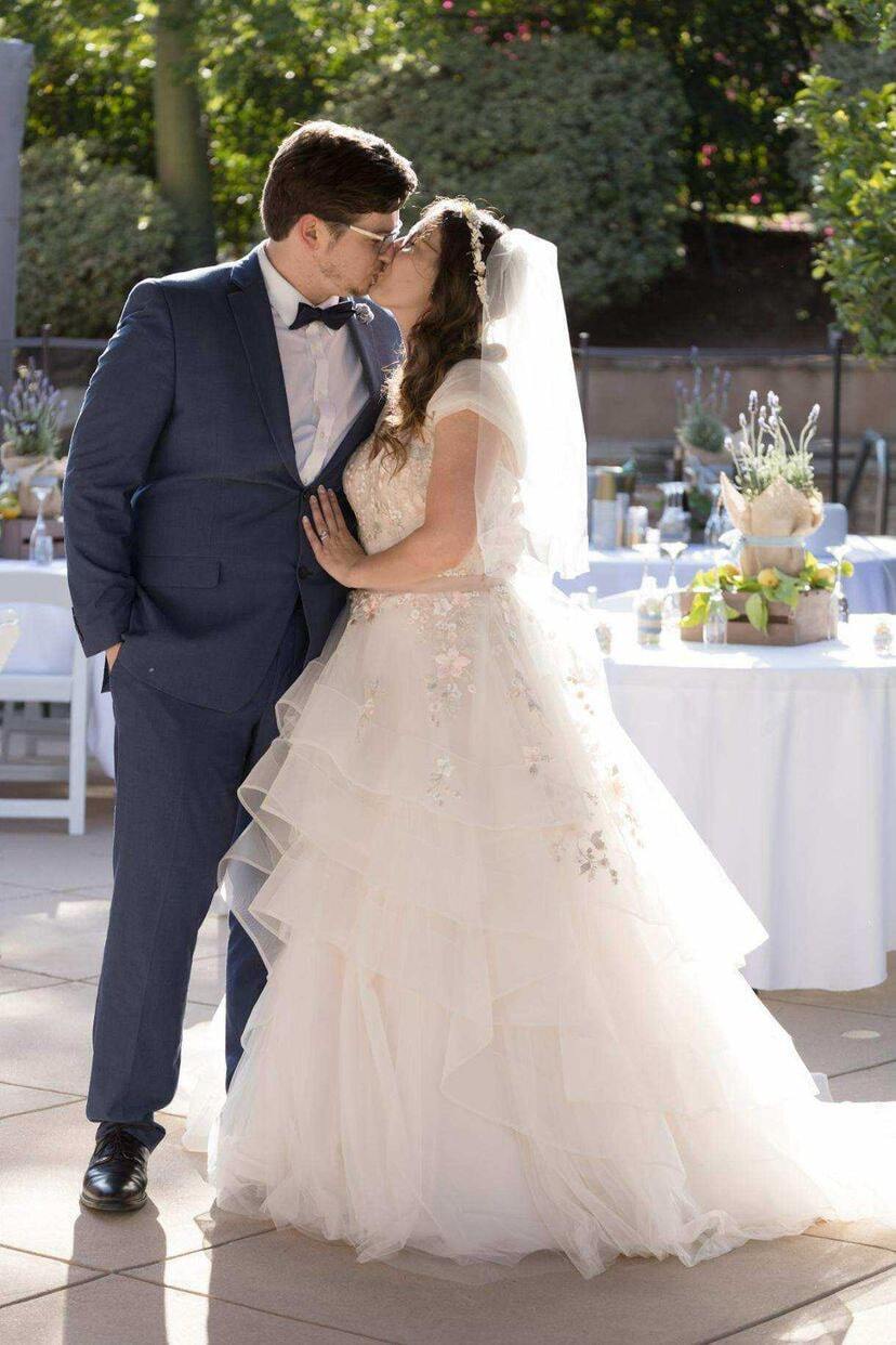 Kissing couple wearing a white gown and a blue suit
