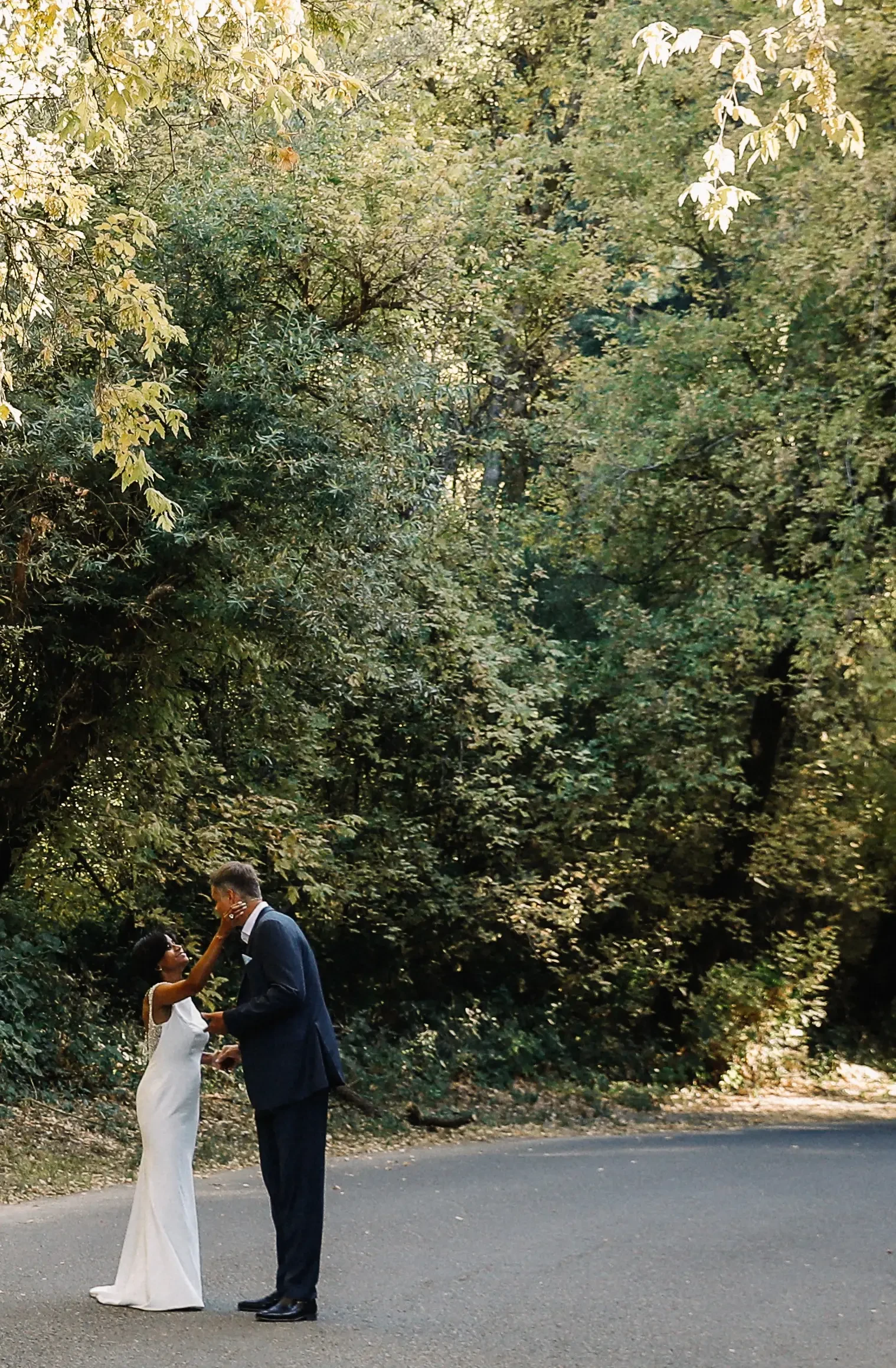Сouple wearing a white gown and a black suit on the road