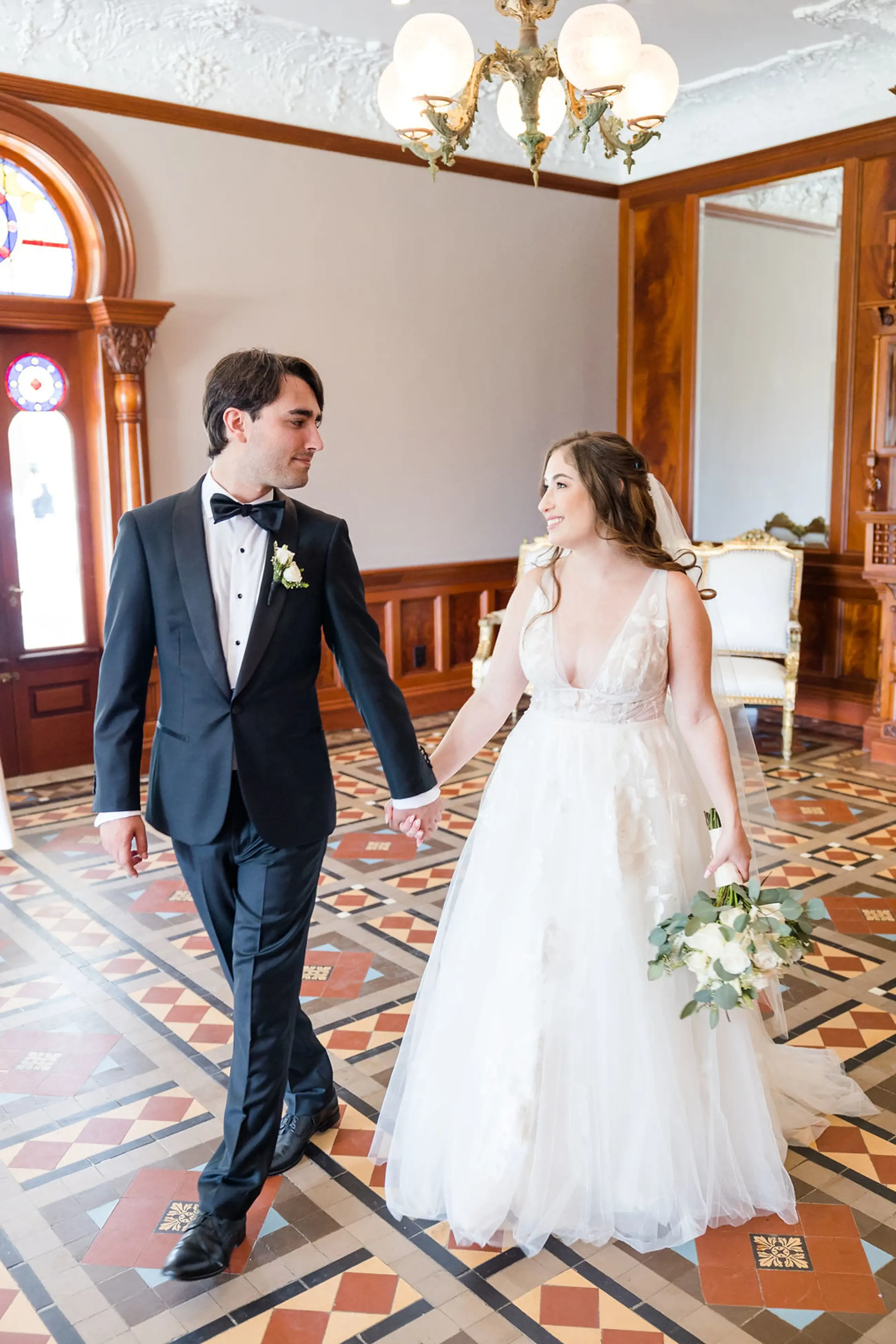 Сouple wearing a white gown and a black suit in the hall