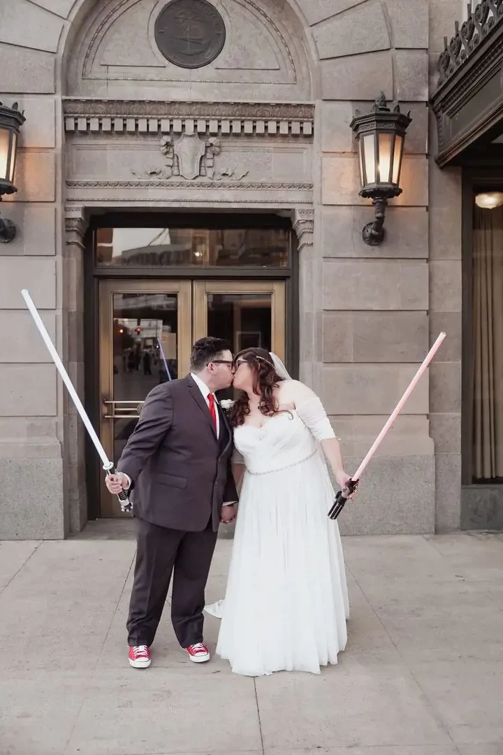 Kissing couple wearing a white gown and a dark-gray suit