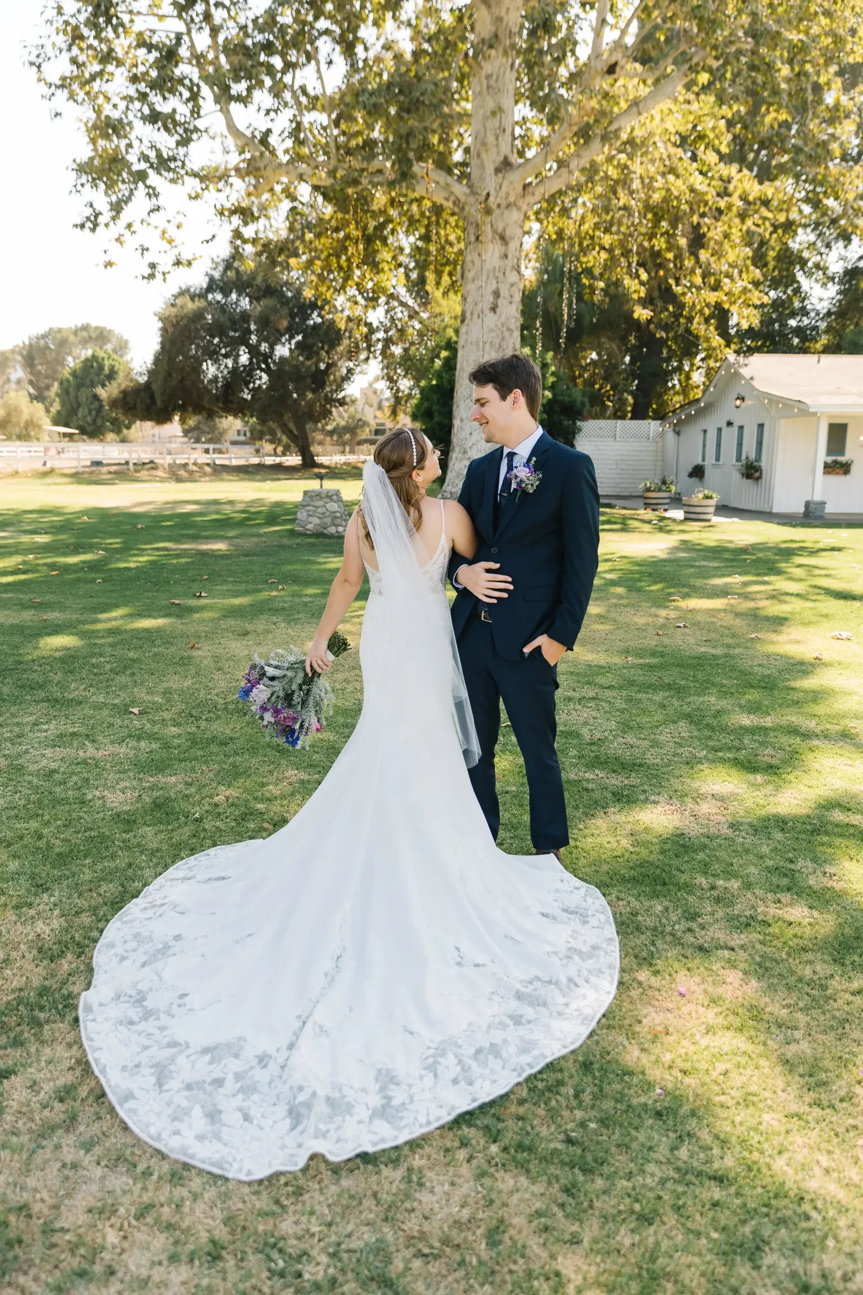 Сouple wearing a white gown and a black suit on the grass