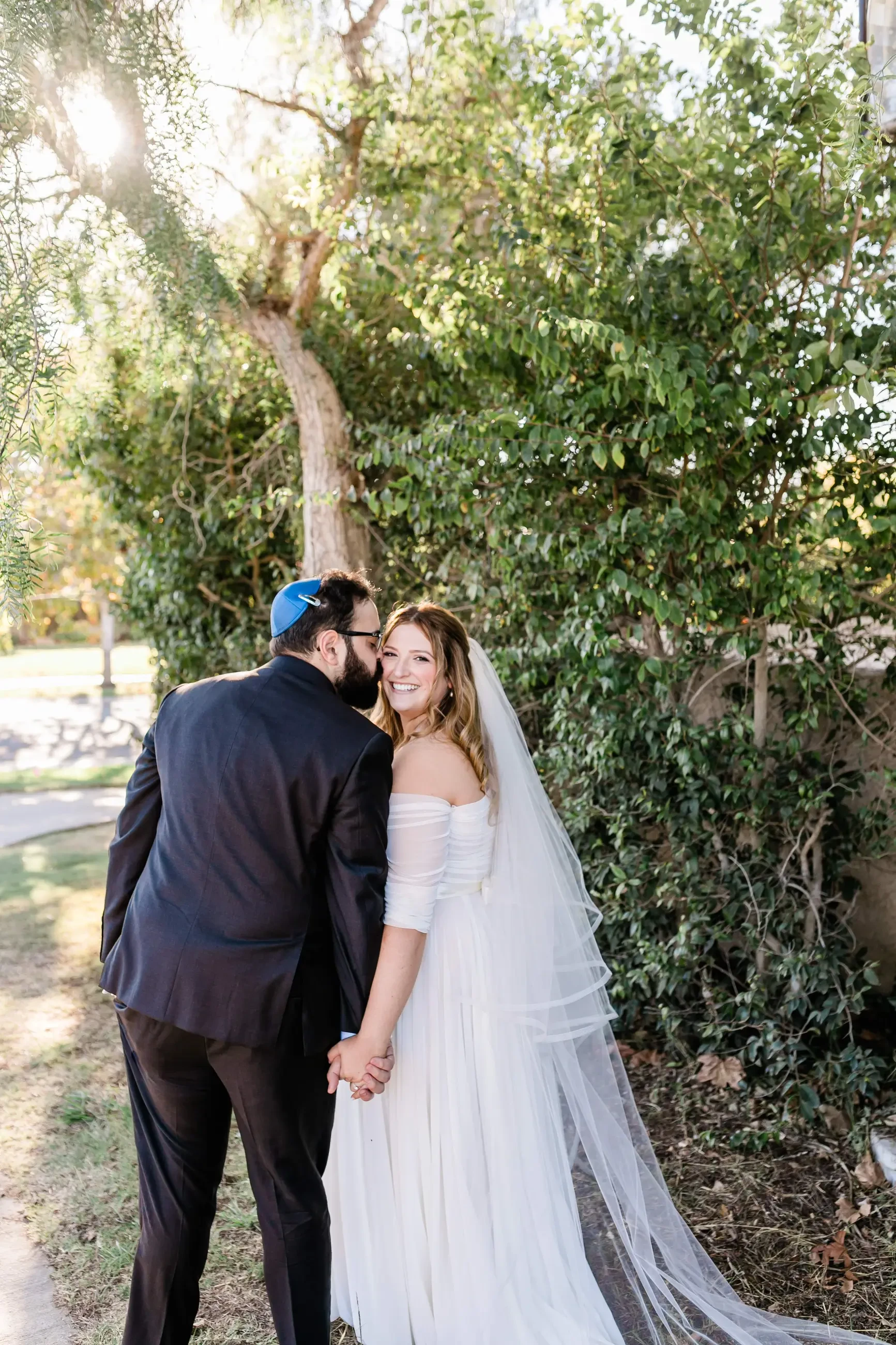 Kissing couple wearing a white gown and a black suit