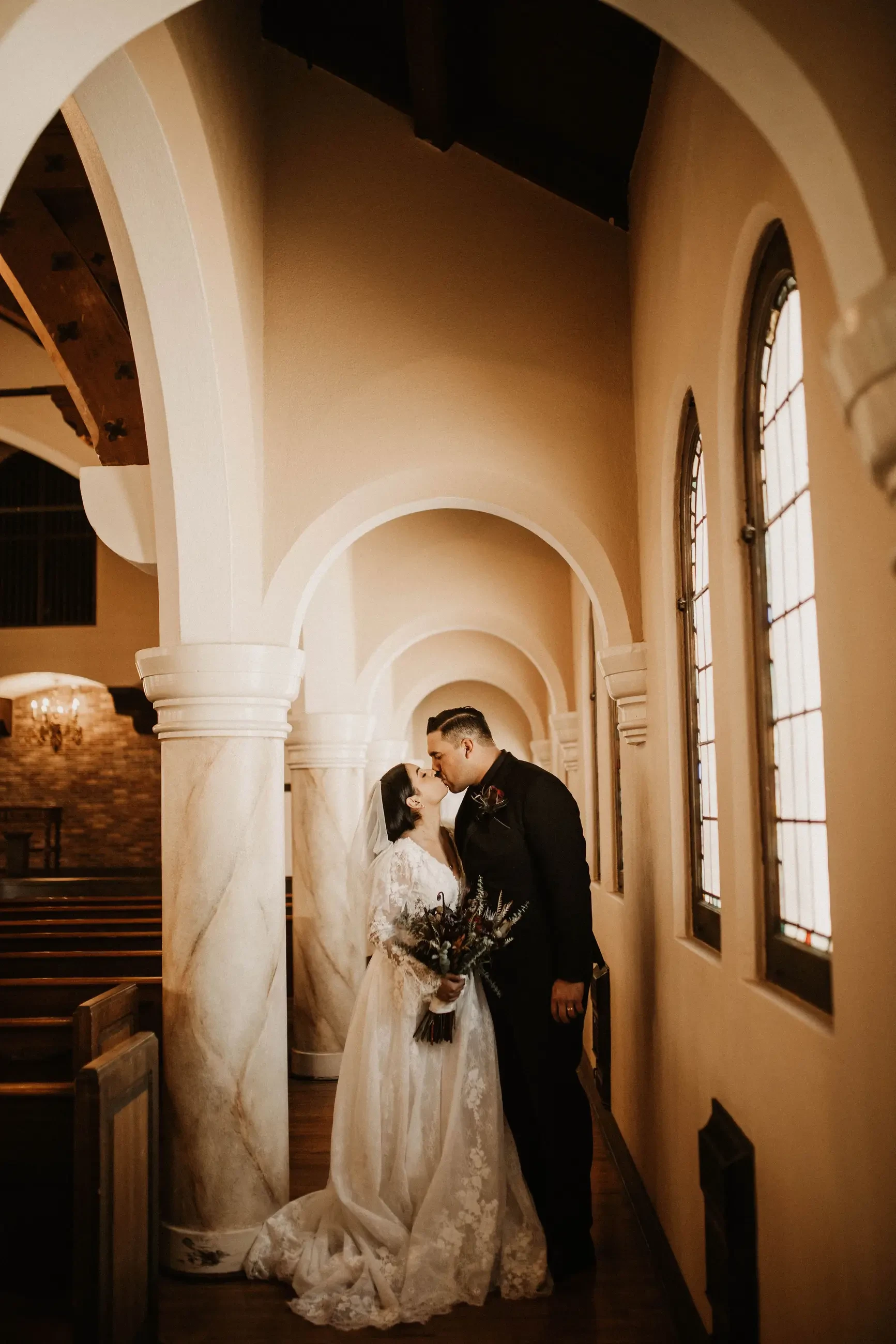 Сouple wearing a white gown and a black suit in the hall