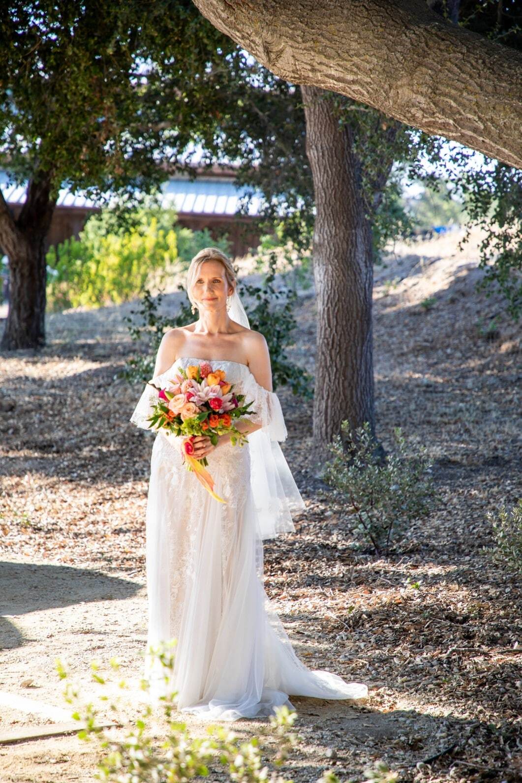 Model wearing a white gown under tree