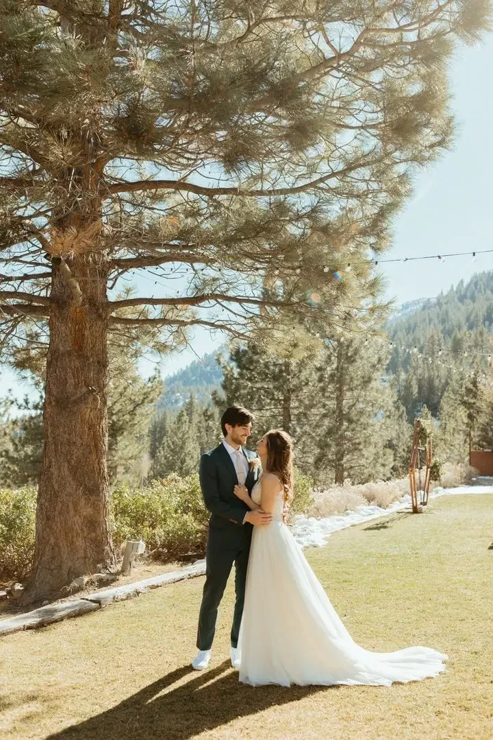 Сouple wearing a white gown and a black suit on the grass